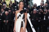 Izabel Goulart vollbringt auf der Premiere von "Le Comte De Monte-Cristo" in Cannes eine modische Glanzleistung. Ihr gewagtes Kleid aus weißem Stoff mit schwarzen Blumenapplikationen und raffinierten Spitzen-Details setzt nicht nur ein modisches Statement, sondern auch ihre beeindruckenden langen Beine perfekt in Szene.