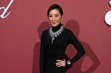 Michelle Yeoh bezaubert im dunklen Langarm-Dress von Bottega Veneta. Ein großes Collier, Ohrringe und Armreif verleihen dem Look noch mehr Glanz. 