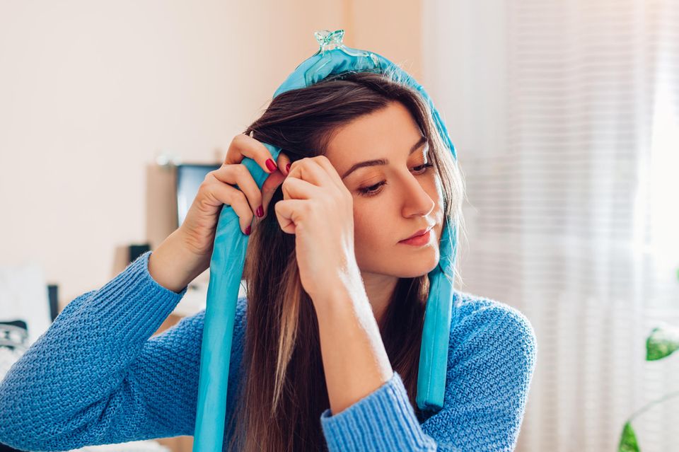 Locken über Nacht: Eine Frau wickelt ihre Haare um ein Seiden-Band