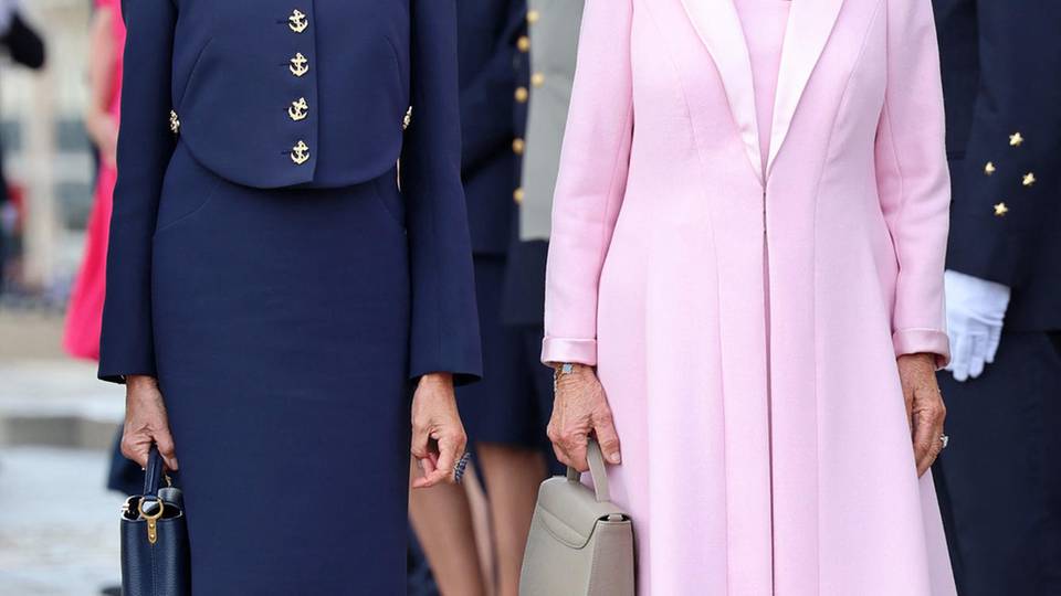 Am Arc de Triomphe in Paris gesellt sich Brigitte Macron im November 2023 zu Königin Camilla. Ihr Outfit wählt sie in klassischem Navyblau.