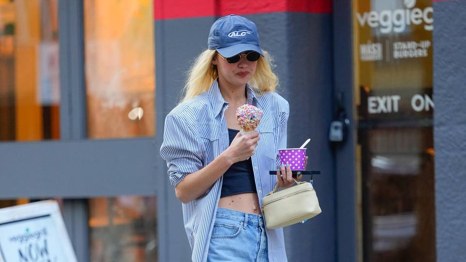 Mit einem Eis in jeder Hand: Gigi Hadid ist in einem Casual-Look in New York unterwegs. Die lässige Bermudas aus Jeans wird durch ein gestreiftes Oversize-Hemd und Sneaker ergänzt.