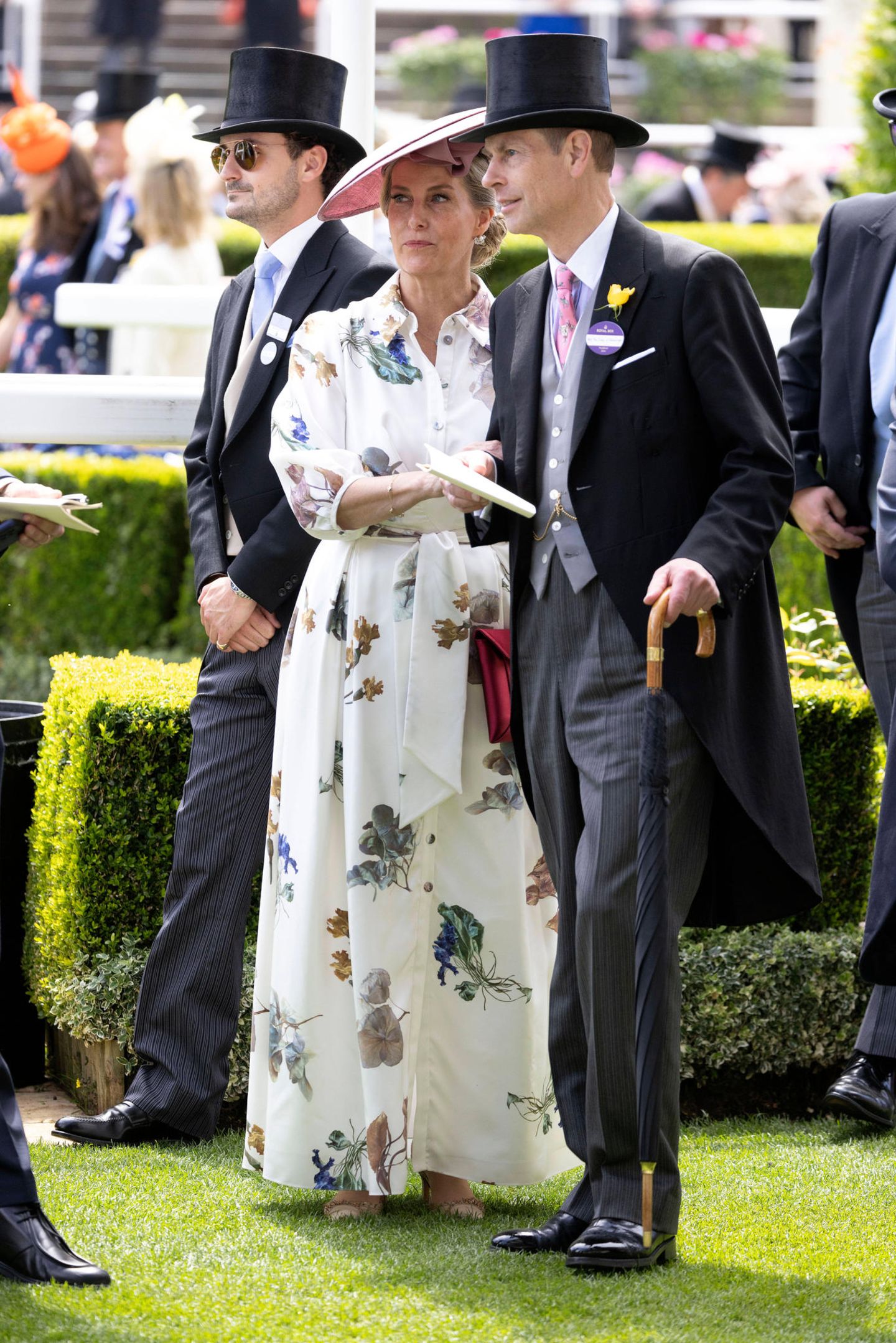 Ganz bezaubernd sieht auch Herzogin Sophie im cremefarbenen Blumenkleid mit Knopfleiste aus. Prinz Edward gibt an ihrer Seite aus im Frack natürlich den perfekten Gentleman.
