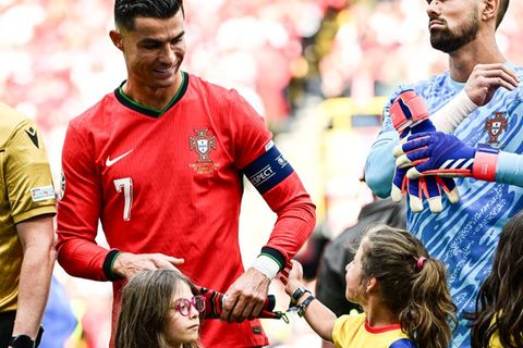 Fußball-EM 2024: Fußball-Superstar Cristiano Ronaldo wird von dem kleinen Einlaufmädchen am Arm berührt.