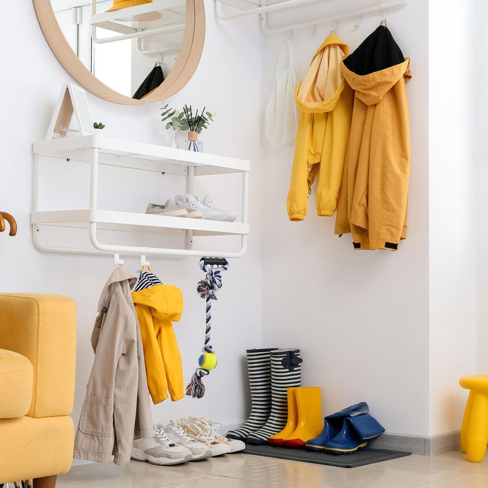 Kleinen Flur gestalten: Garderobe, Gummistiefel und eine gelbe Couch