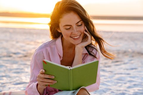 Bücher im Sommer 2024: Frau liest am Strand Buch