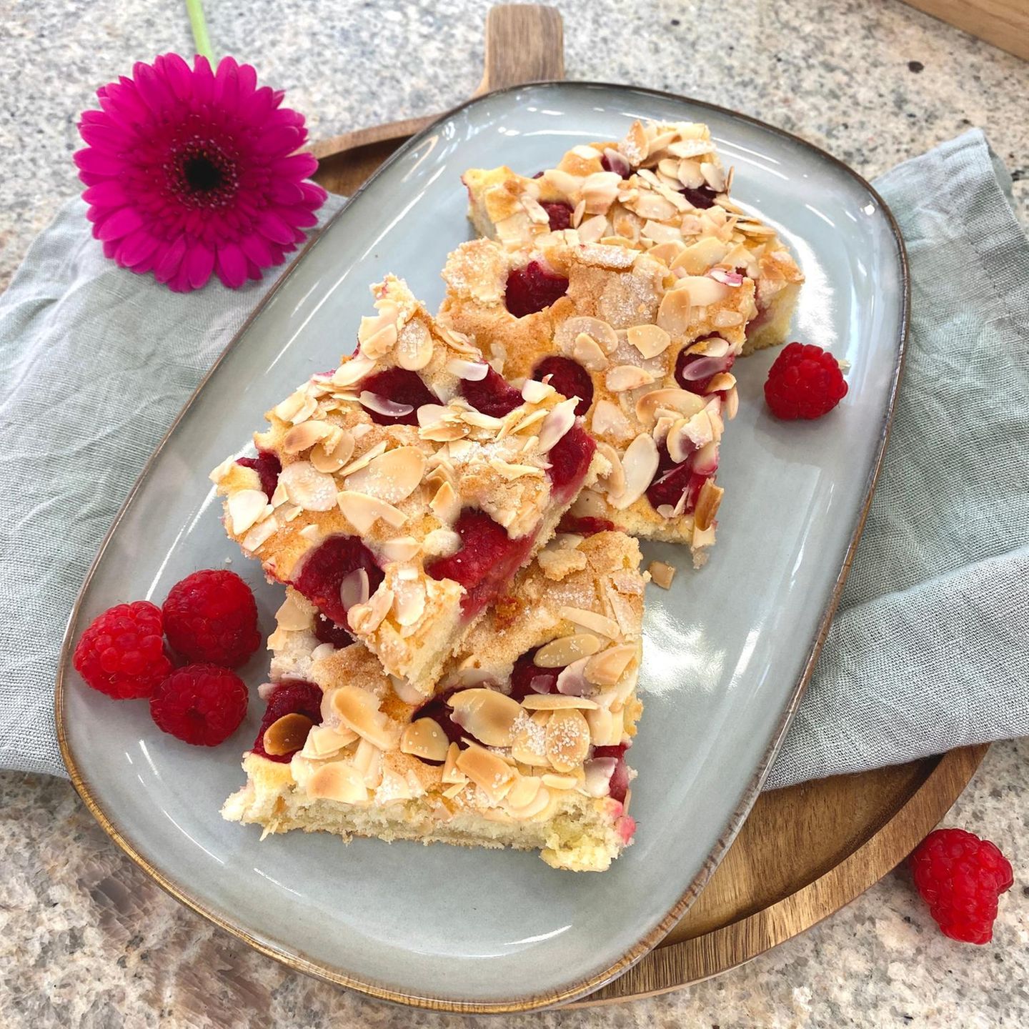 Himbeerkuchen-Stücke auf einem Teller mit Himbeeren drapiert