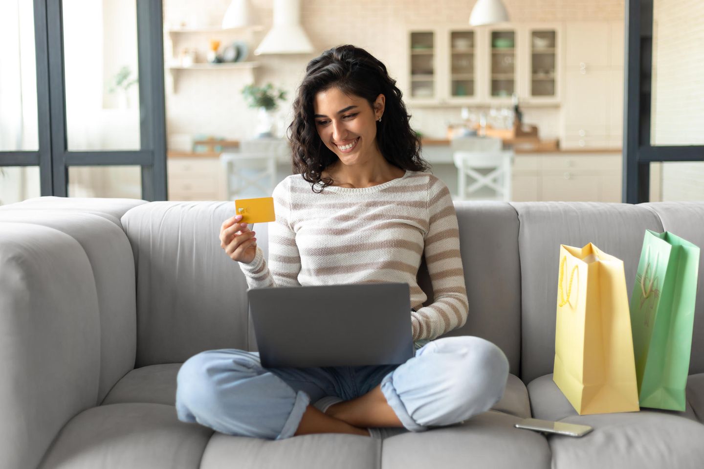 Amazon Prime Day: Lächelnde Frau mit Laptop und Kreditkarte