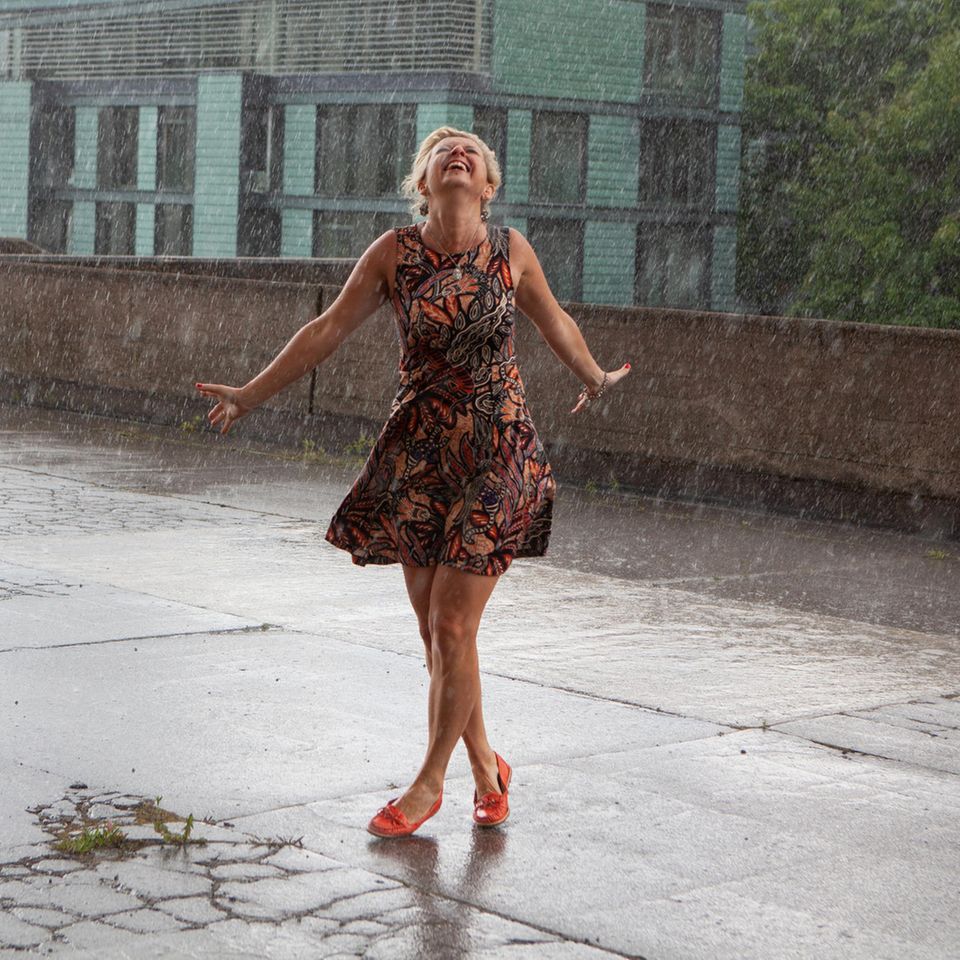 Frau tanzt im Regen