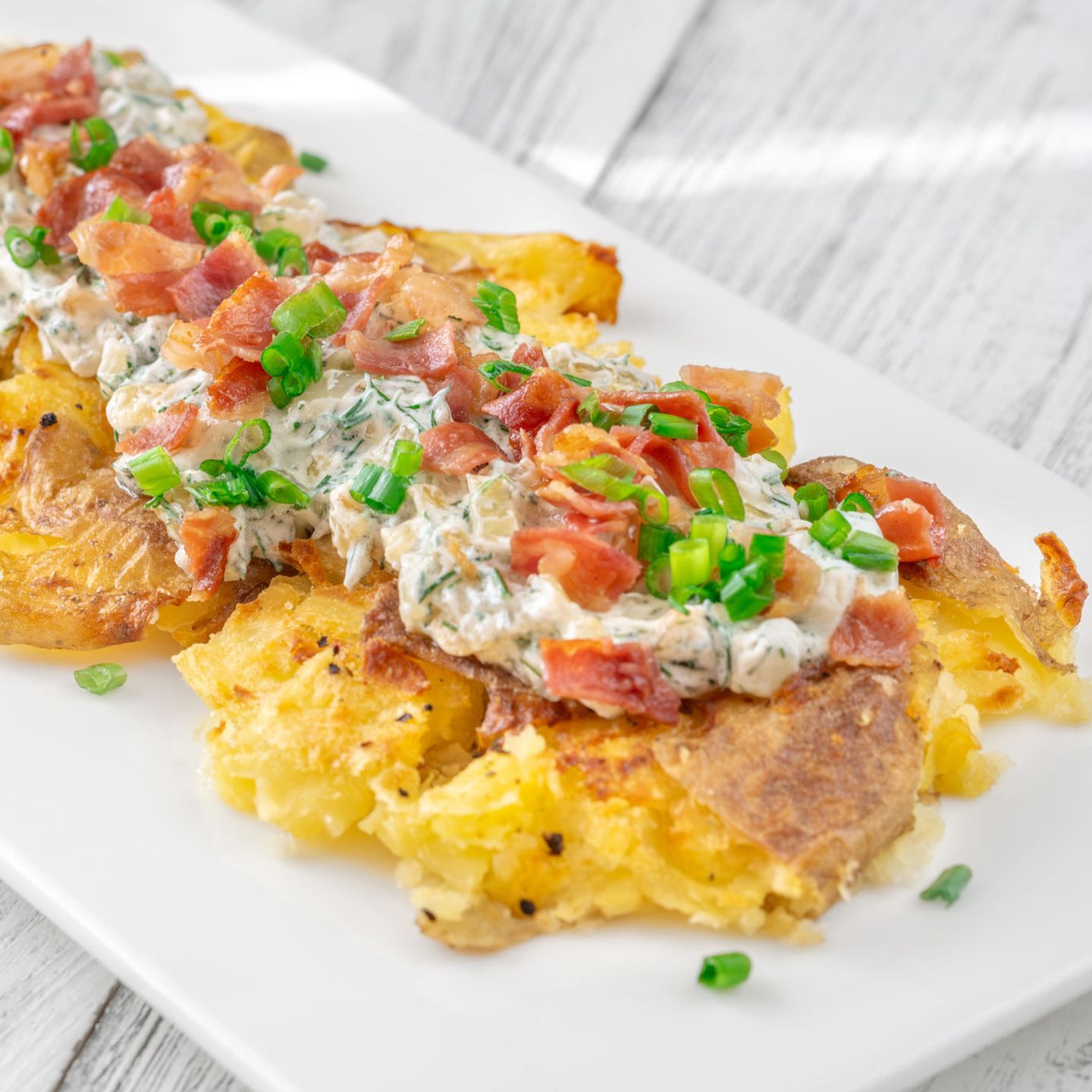 zerstampfte Kartoffeln überbacken mit Käse, Creme Fraiche, Schnittlauch und Schinken