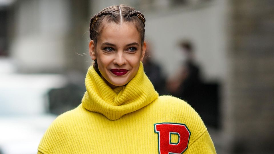 Frau trägt Boxer Braids als Flechtfrisur zur Fashion Week. 