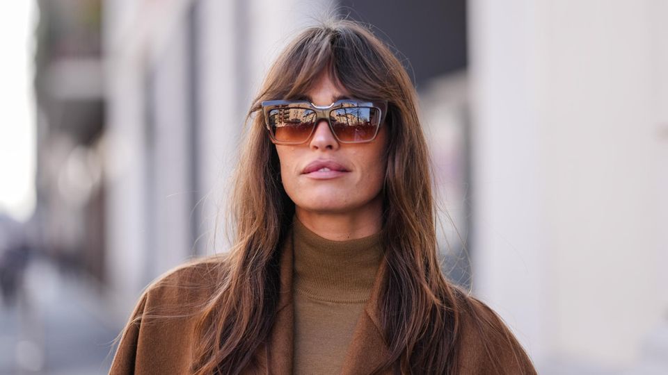 Frau trägt Curtain Bangs zur Fashion Week in Mailand. 