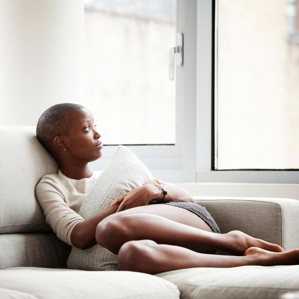 Psychologie: Eine nachdenkliche Frau auf einem Sofa