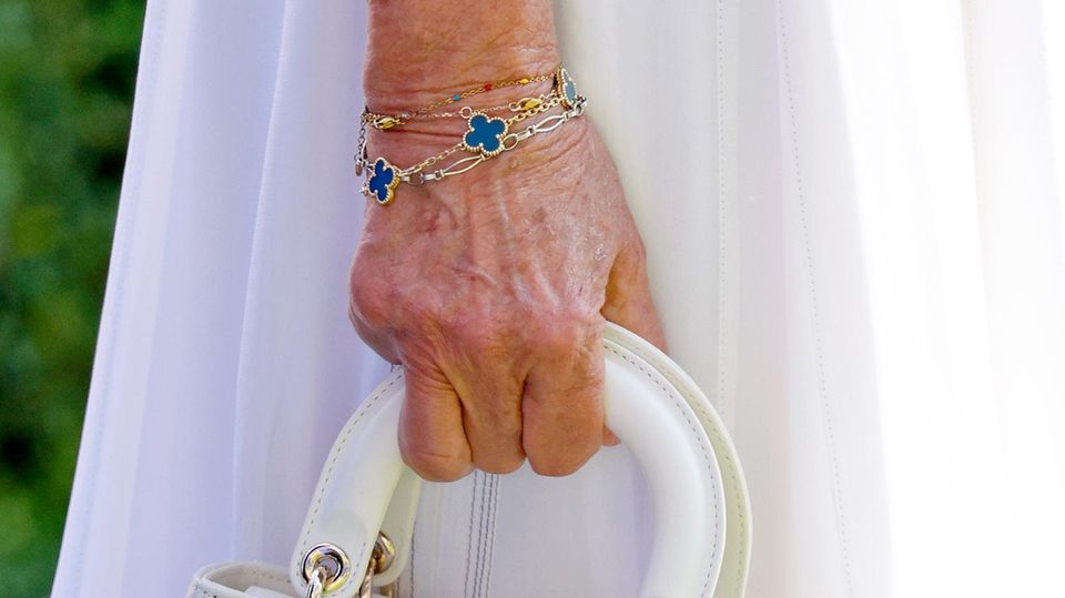 Bei ihren Accessoires investiert Königin Camilla in zeitlosen Luxus. Unter ihren Handtaschen befindet sich eine Lady Dior Bag und eine Black Quilted Mini Top Handle Bag von Chanel. 