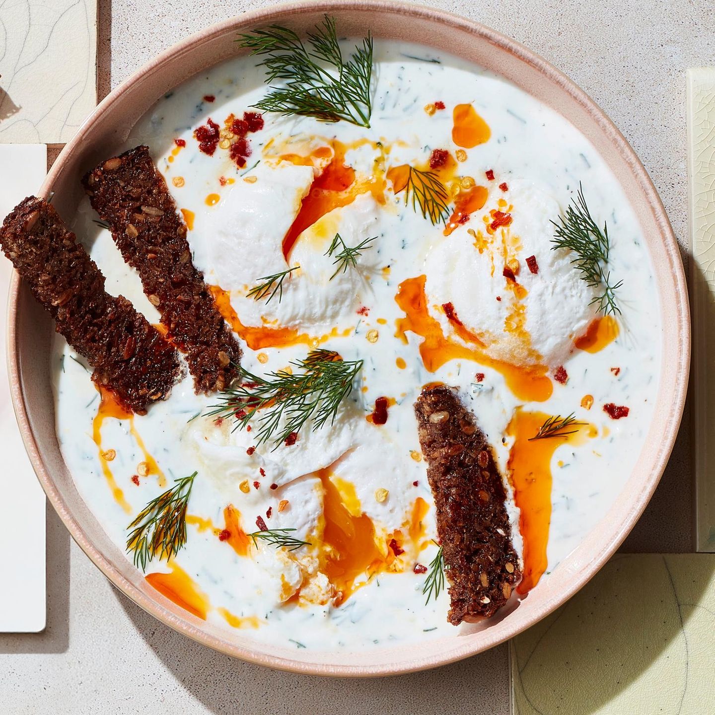 Çilbir mit Dill-Joghurt, Paprikaöl und Vollkornbrot