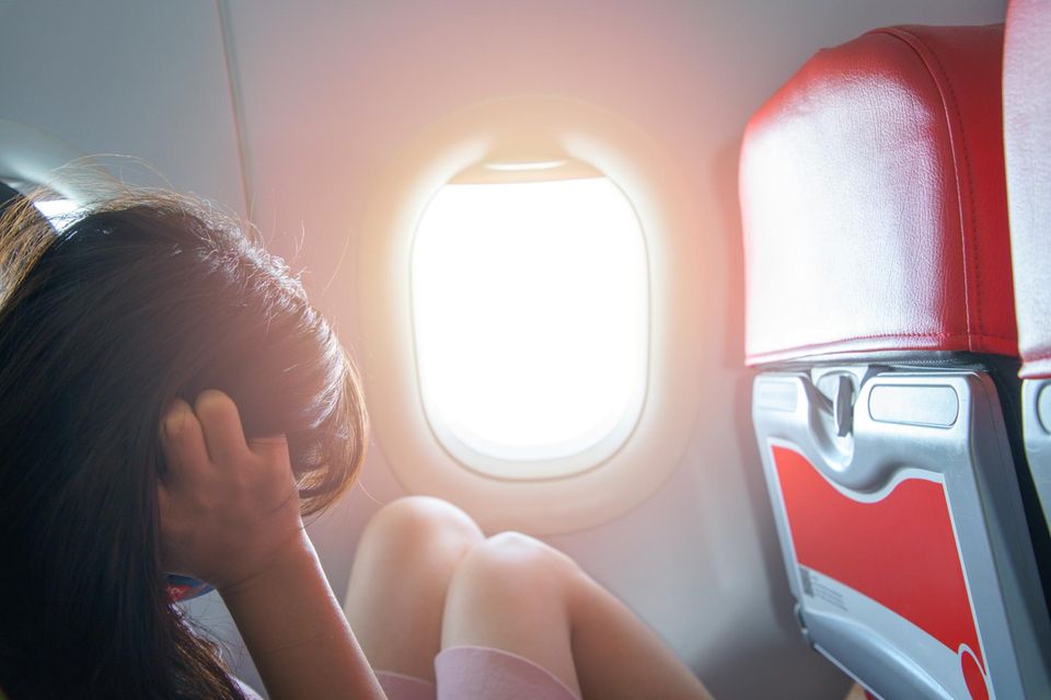 Ängstliche Frau im Flugzeug: Wie die Schwebe-Hypnose dir blitzschnell gegen Flugangst hilft