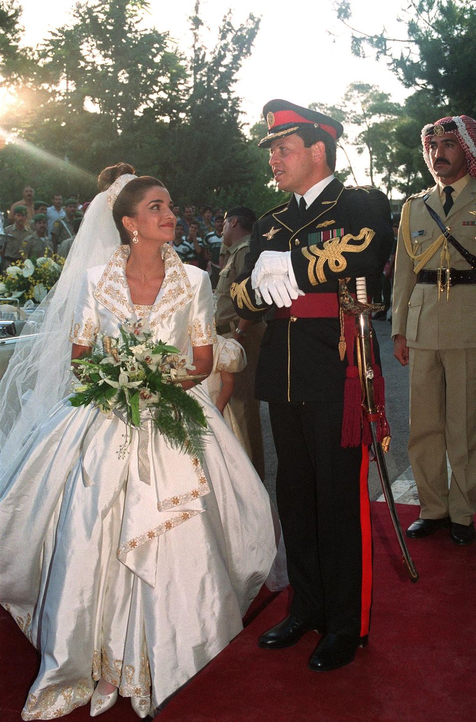 A Rainha Rania e o Rei Abdullah trocam olhares amorosos no dia do casamento.