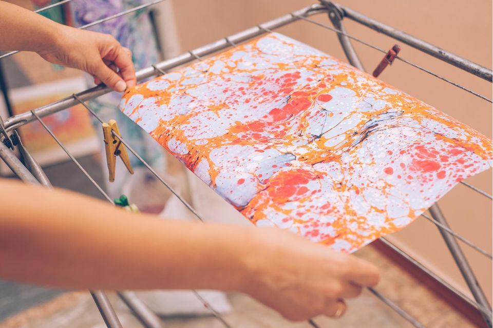 Marmorieren: Marmoriertes Papier liegt auf einem Wäscheständer zum Trocknen