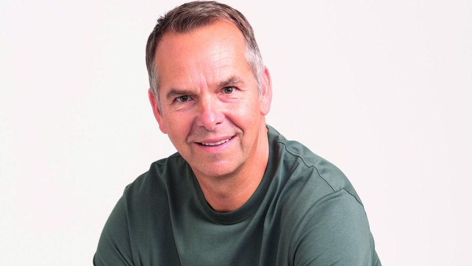 Dr. Stephan Barth im grünen T-Shirt, auf einem Stuhl sitzend